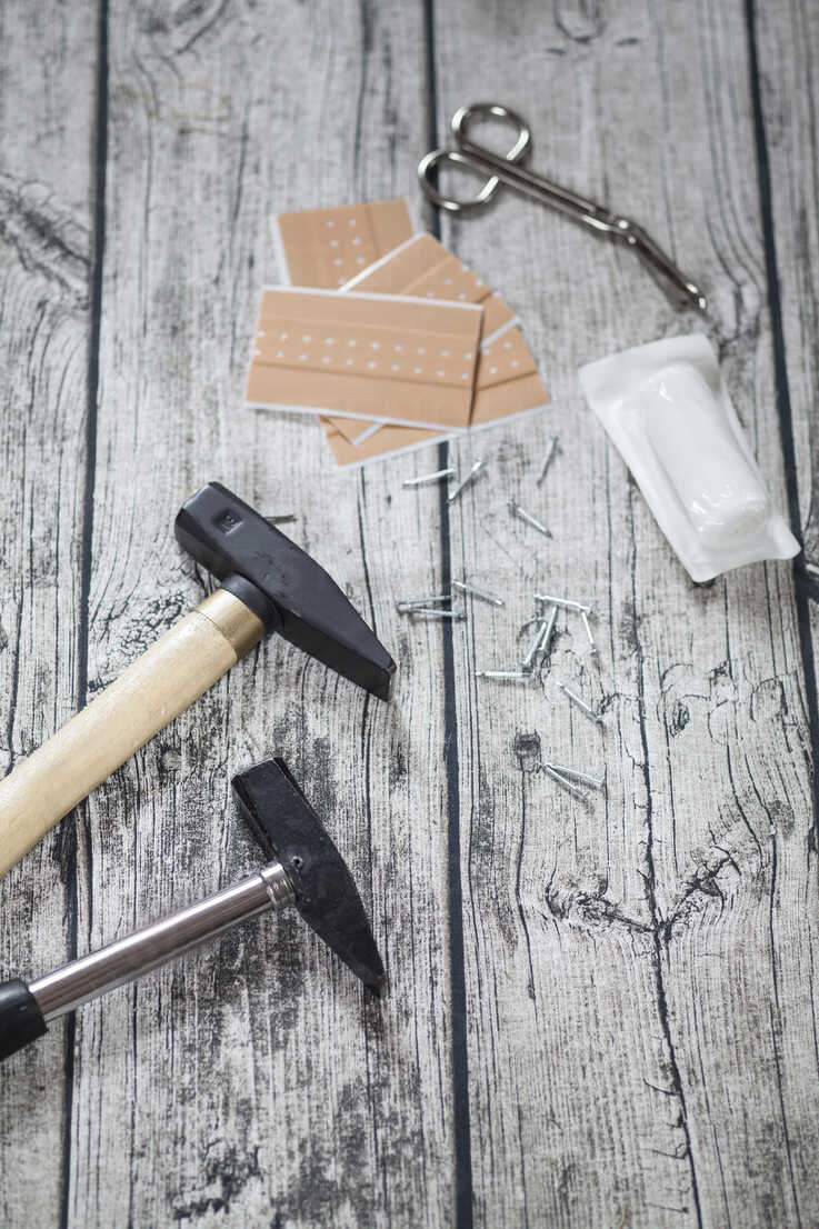 Hammer, nails, band-aids, bandage and scissors on grey wood ...