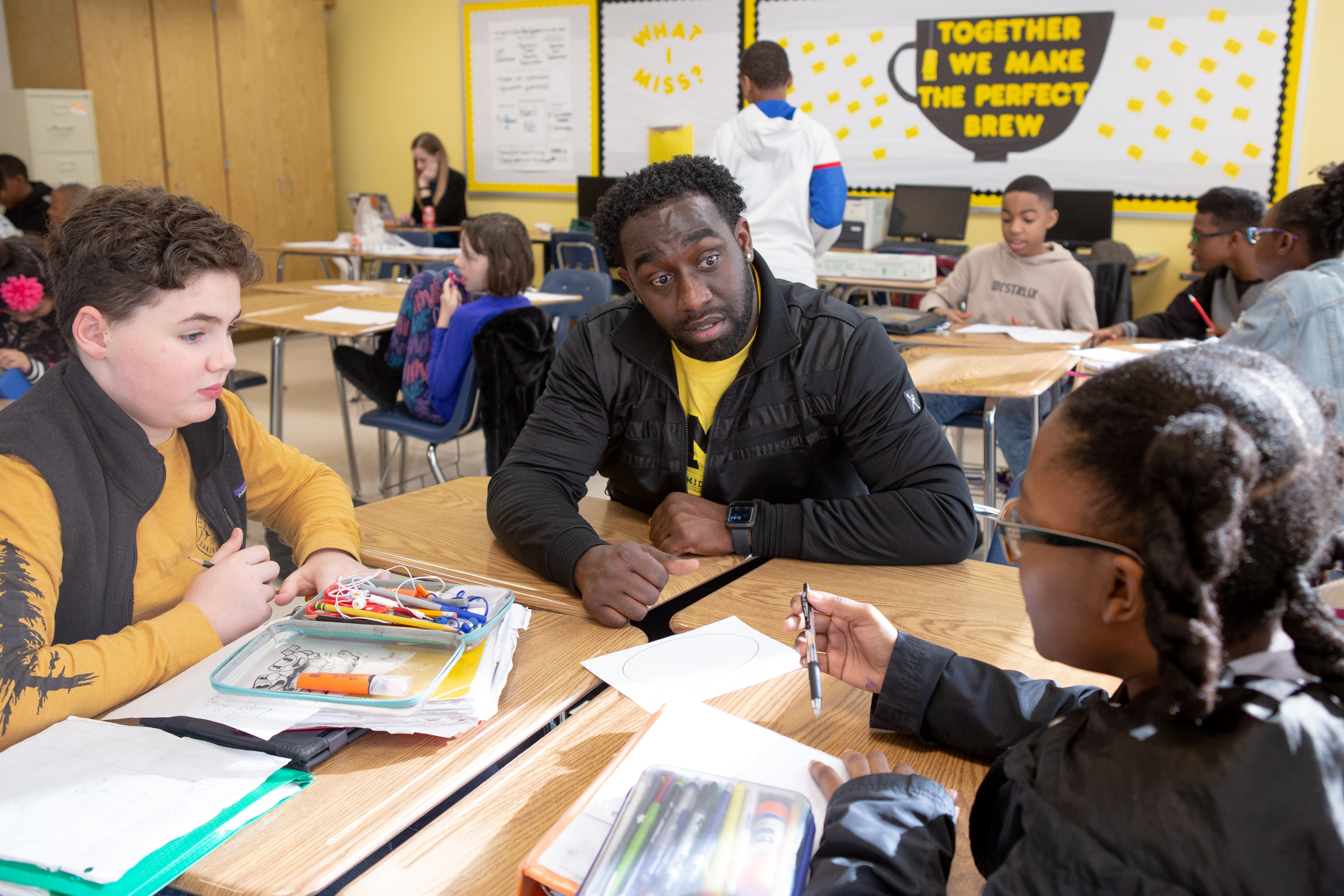 Male middle school math teacher with two sixth-grade students ...